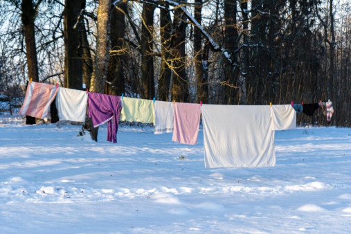 Lumpen und Tücher hängen draussen an der Wäscheleine. Es liegt Schnee auf dem Boden.