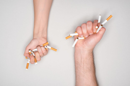 zwei Hände zerdrücken Zigaretten