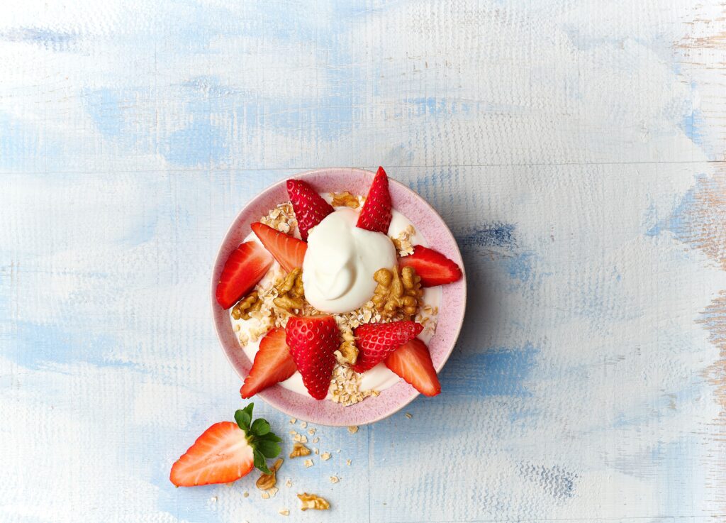Yoghurt in Schüssel mit Erdbeeren