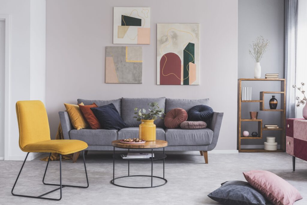 ein angenehmes, sauberes Wohnzimmer mit grauem Sofa und gelben Akzenten