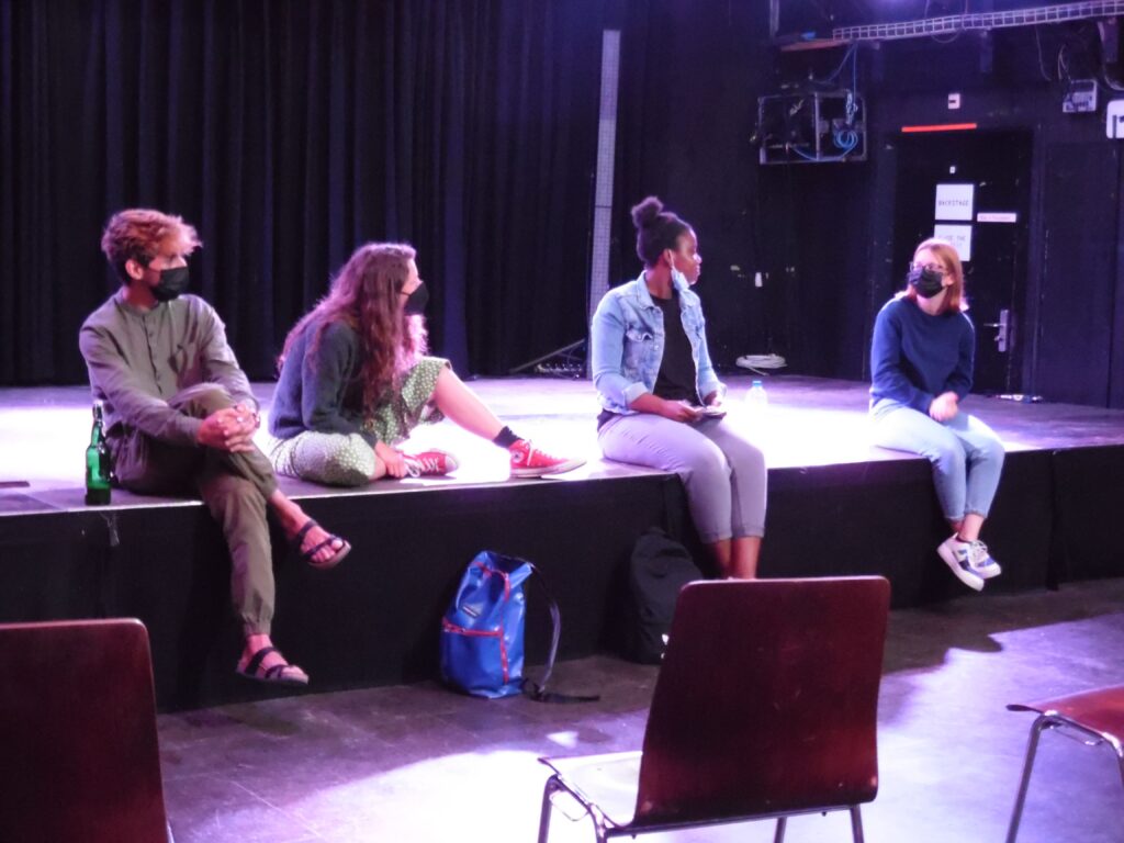 Grafiker Baran Şanli, Studentin der Theaterpädagogik Melanie Guntern, die Moderatorin Claudia Fuila und eine Schülerin der Fachmittelschule sitzen auf der Bühne der i45.