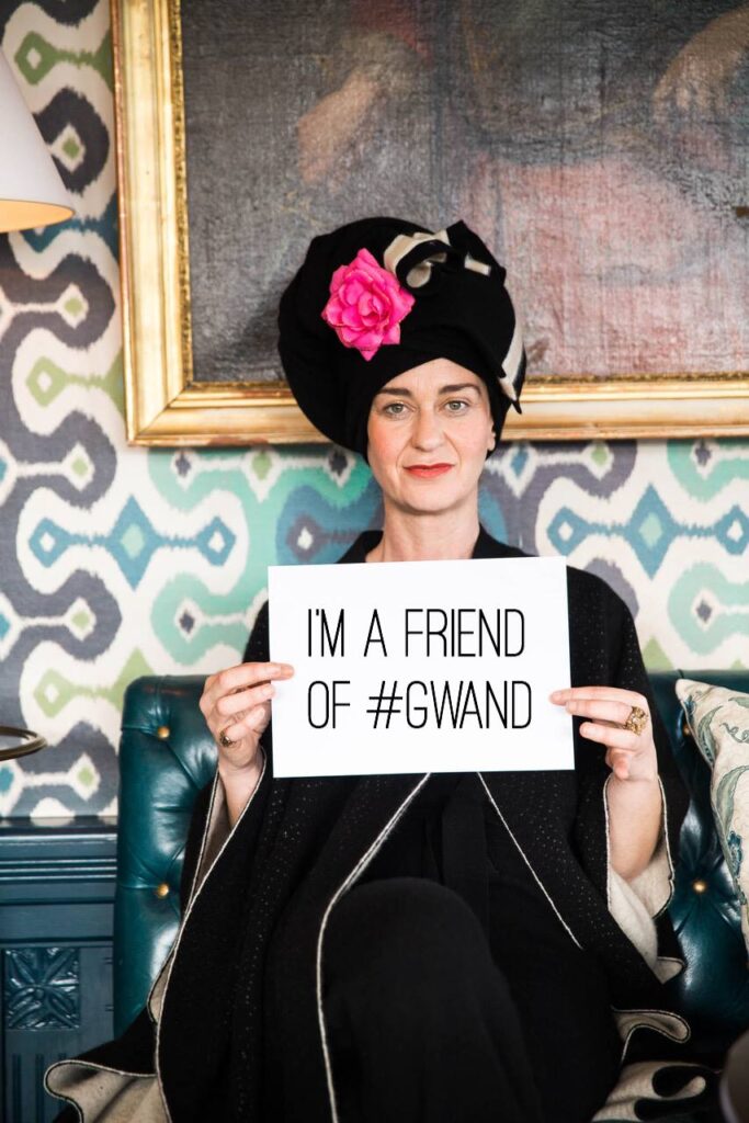 Ein Protrait von Suzanna Vock mit Tourban und einem Blatt Papier in den Händen. Auf dem Blatt steht "I'm a friend of #Gwand".