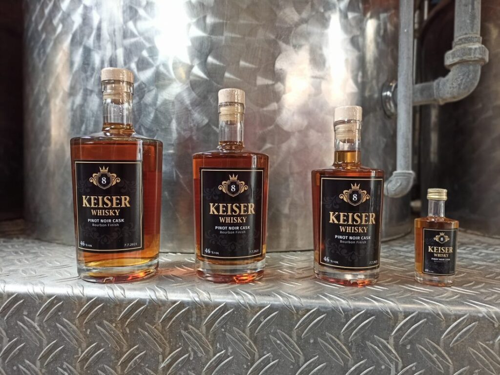 Vier verschiedengrosse Flaschen Whisky stehen auf dem Tresen der Brennerei.