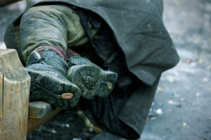 Obdachlose Person im Winter auf Bank
