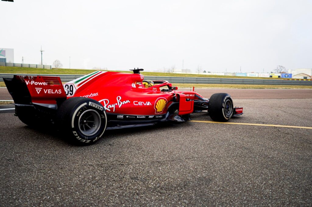 Ein rotes Rennauto von Ferrari steht auf der Rennstrecke.