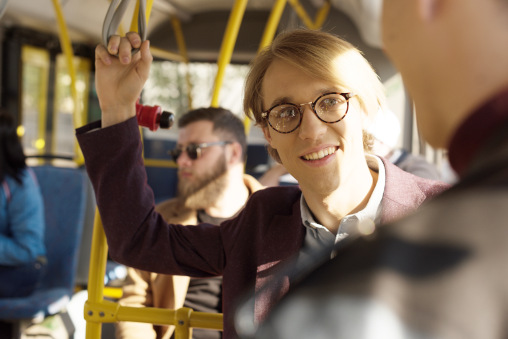 Mann mit Brille lächelt im Bus