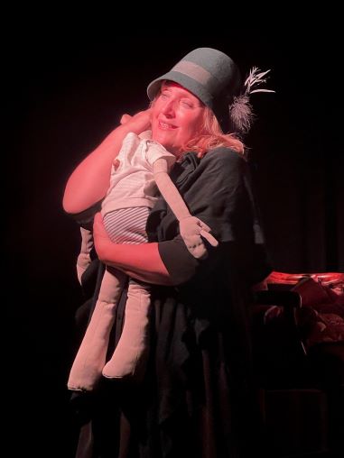 Dunjascha umarmt eine Puppe auf der Bühne für das Stück Oskar und die Dame in Rosa