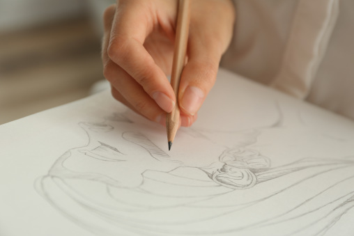 Hand mit Bleistift malt eine Frau auf Papier