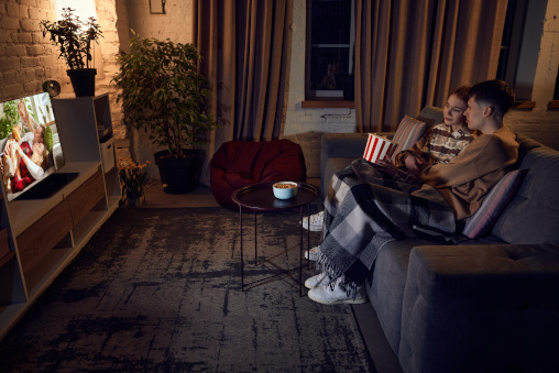 Junges Paar auf der Couch guckt Fernsehen