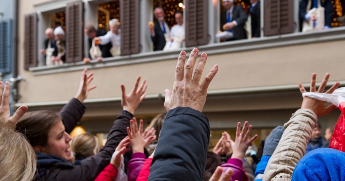Das Publikum streckt die Hände nach den Brötchen der Zunft aus.