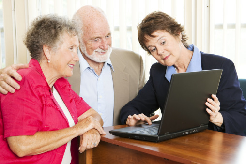 Altersarmut in Zug - Älteres Paar wird von Frau mit Laptop beraten