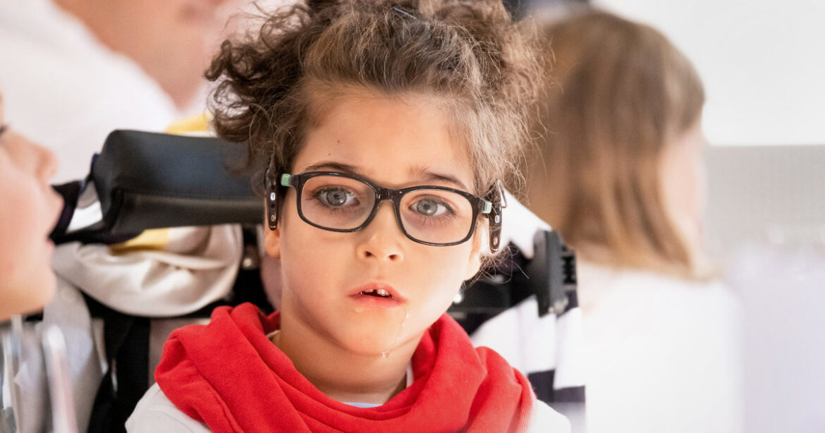 Kind im Spezialrollstuhl; seltenen Krankheiten