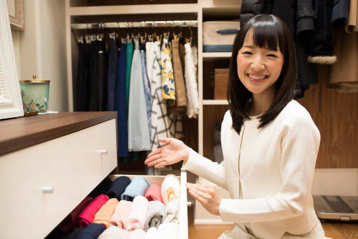 Marie Kondo vor Schublade mit Kleidung