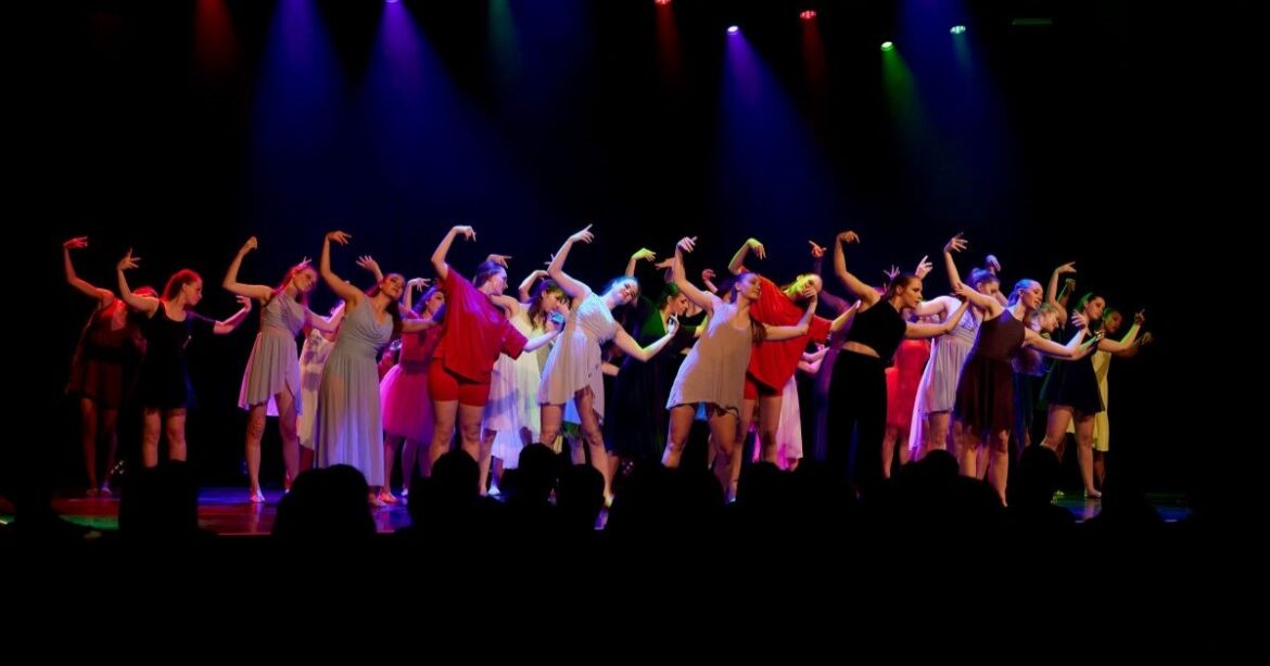 Die TDC Dance School & Company in farbiger Kleidung auf der Bühne