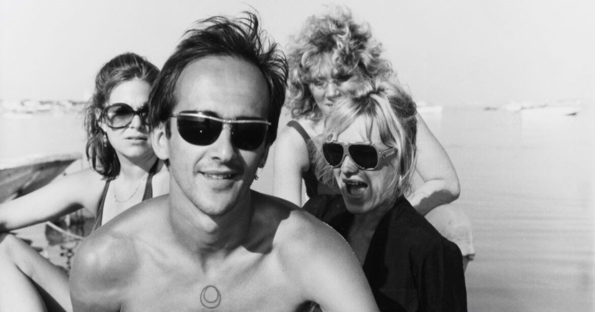 Eine schwarz-weiss-Fotografie von einem Mann mit drei Frauen in einem Boot.