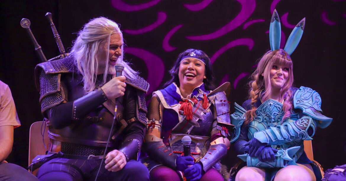 Drei CosplayerInnen sitzen auf der Bühne