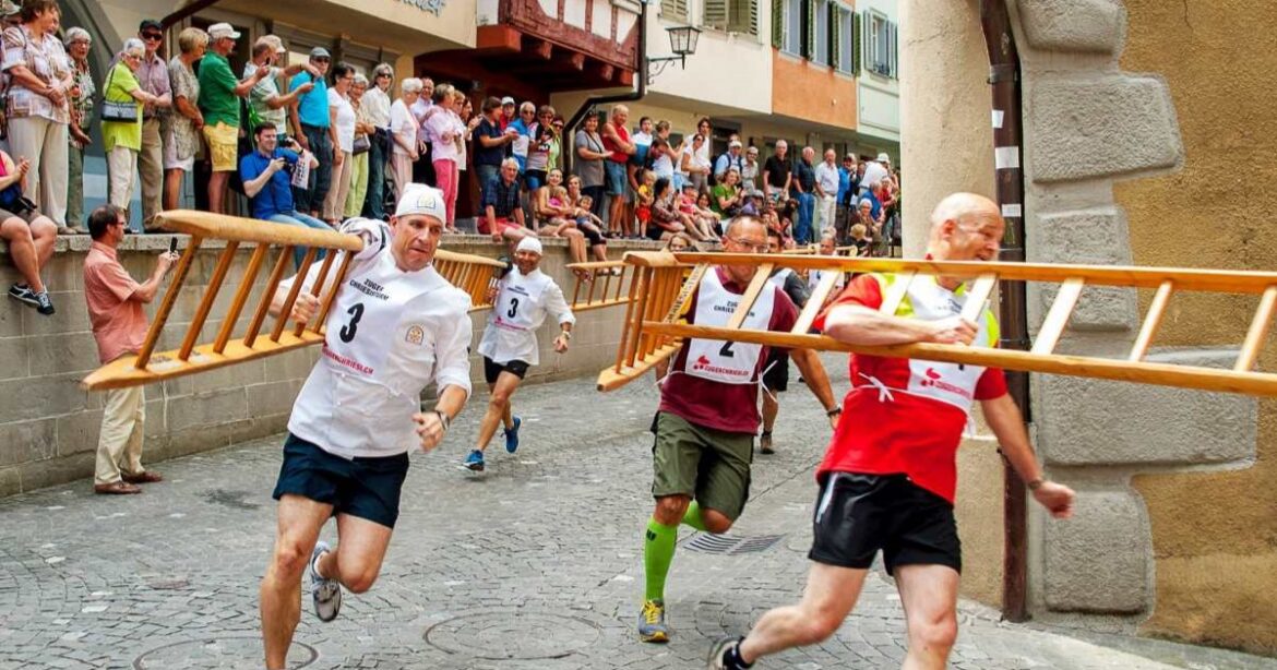Männer rennen mit Leitern auf den Schultern durch die Zuger Altstadt.