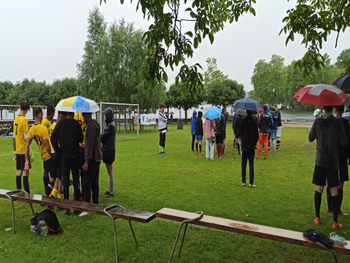 dorfturnier9 Spieler stehen unter dem Regenschirm am Chamer Dorfturnier