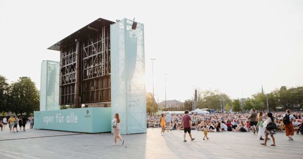 Eine grosse Leinwand steht auf dem Sechseläutenplatz, vor ihr eine Menschenmenge.