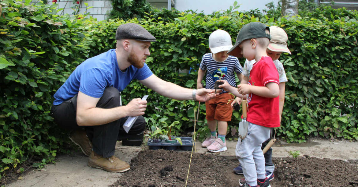 Mann mit drei kleinen Kindern im Garten