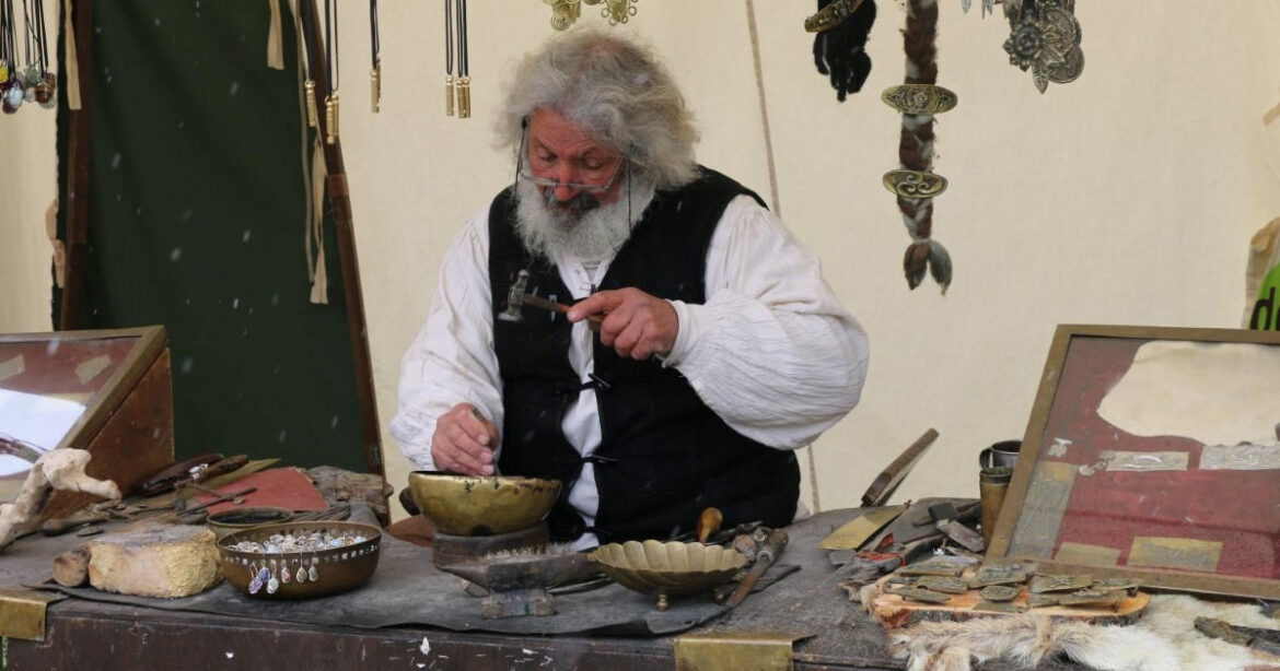 Mann bearbeitet eine Schüssel mit einem Hammer am Mittelaltermarkt Luzern
