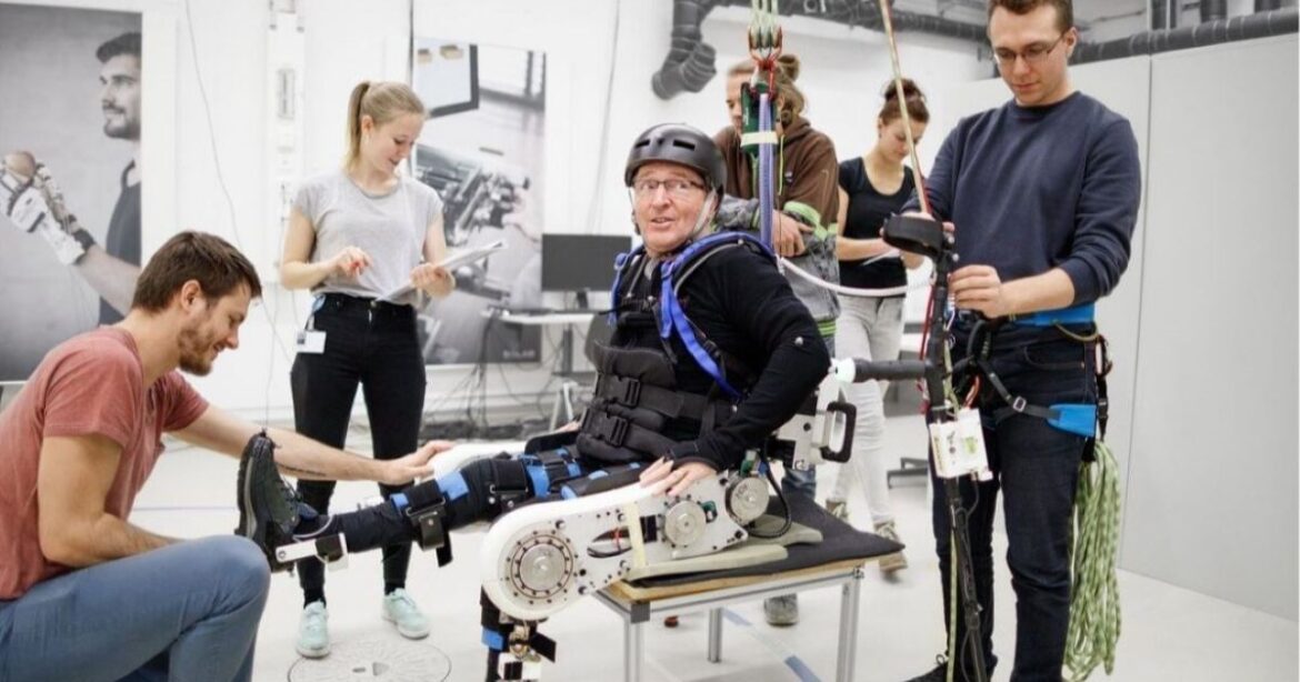 Einem Mann werden am Cybathlon künstliche Beine angezogen.