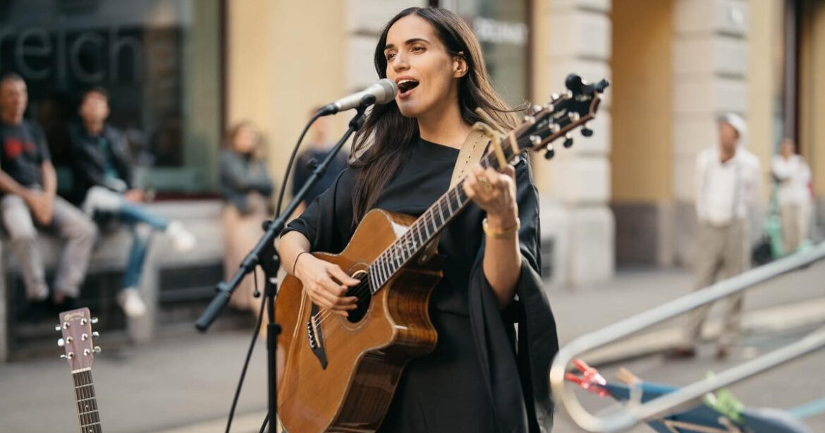 Lea Lu bei ihrem Auftritt am Fresh Open Air in Zürich mit Gitarre in der Hand am Mikrofon singend