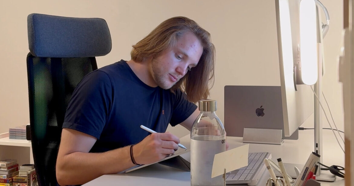 Yves Zumbühl sitzt am Schreibtisch und schreibt