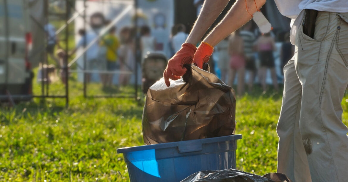 Eine Person sammelt Abfall auf an einem Festival