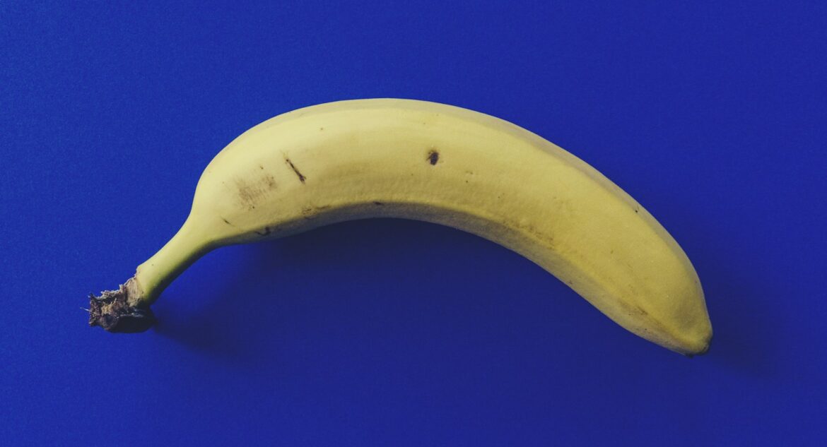 lebensmittelverschwendung, a ripe banana sitting on top of a blue surface