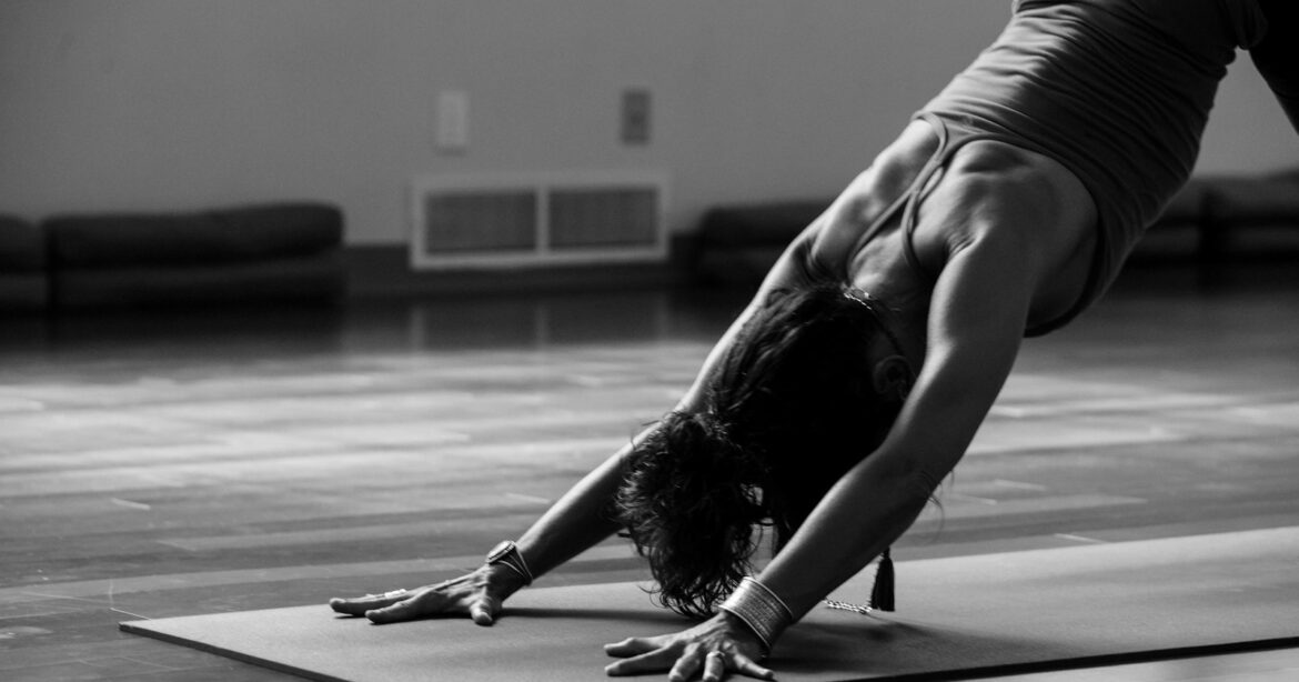 muskelmasse, woman in black tank top and black pants bending her body on floor