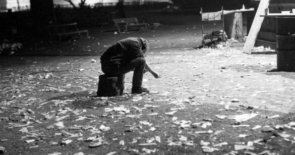 Ein Drogenkonsumierender sitzt mit gesenktem Oberkörper in Zürich