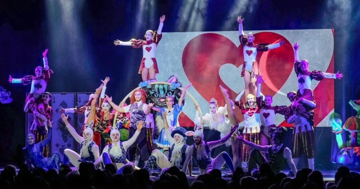 Ein Foto von "Alice in Wonderland", mit zahlreichen Darstellenden in Kostümen auf der Bühne.