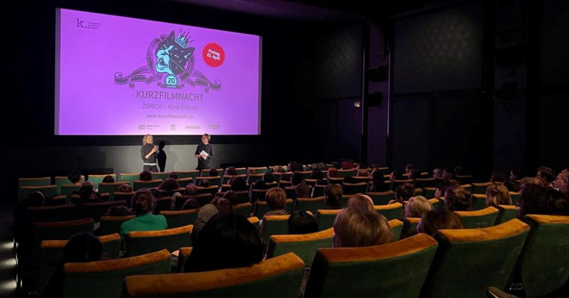 Blick in den Saal des Kino Riffraff in Zürich mit zwei Personen auf der Bühne, die diskutieren. Kurzfilmnacht