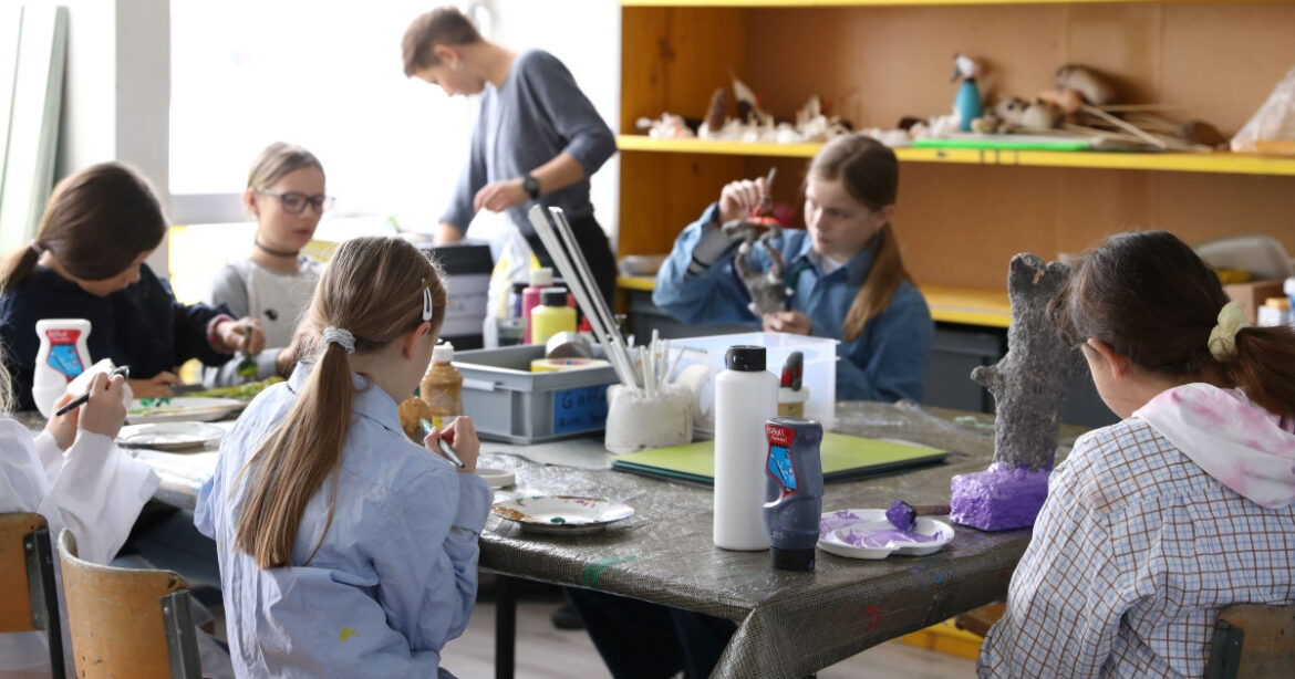 Ein Blick ins K’werk Zug am Tag der offenen Tür. Auf dem Programm steht Plastisches Gestalten in 3D. Kinder sitzen am Tisch und basteln