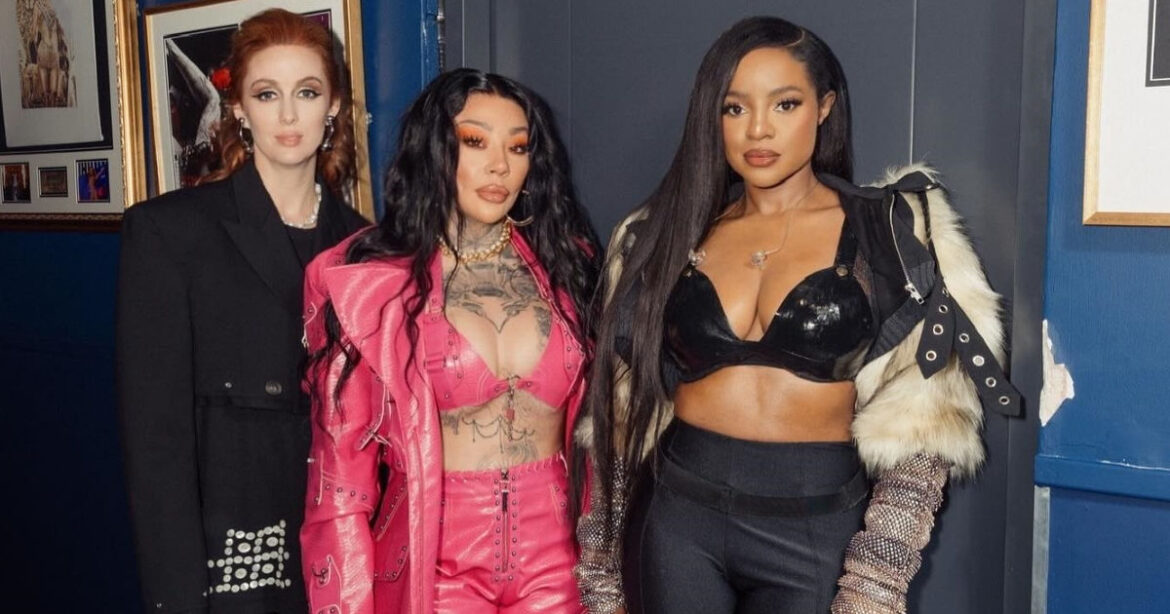 Bandfoto der Sugababes. Sie stehen vor ihrer Garderobe