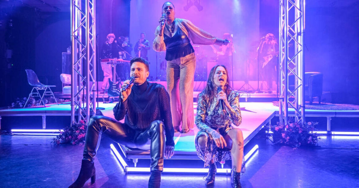 Freda Goodlet, Andreas Lareida und Nina Attal singen auf der Bühne Lieder von Prince. Sie stehen und sitzen beim Performen