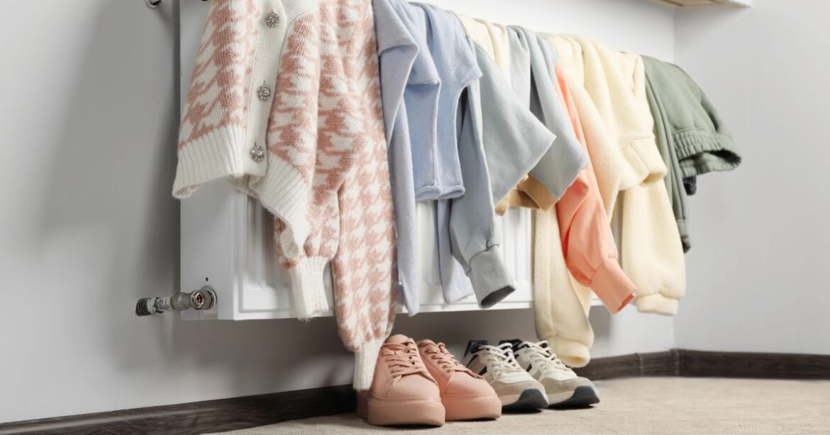 Kleider trocknen auf der Heizung, unter der Heizung stehen Schuhe.