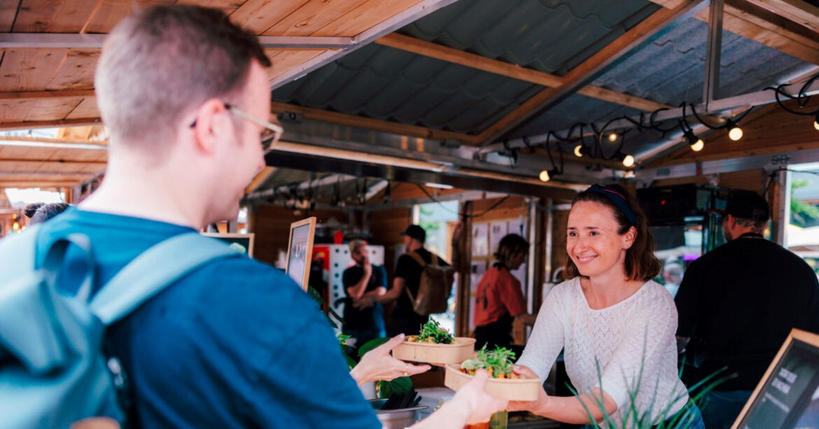 Am Food Zurich wird einem Kunden das Essen am Stand übergeben
