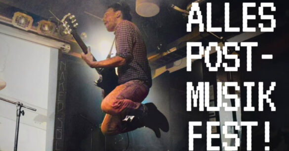 Ein Mann springt auf einer Bühne mit Gitarre auf für das Alles Post- Musikfest