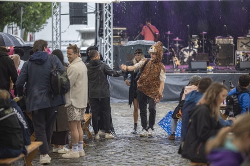 Leute begrüssen sich im Regen am Zuger Seefest auf dem Landsgemeindeplatz