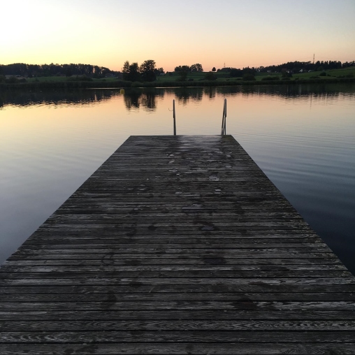 Blick auf den Lützelsee mit Steg und Abendsonne, die untergeht