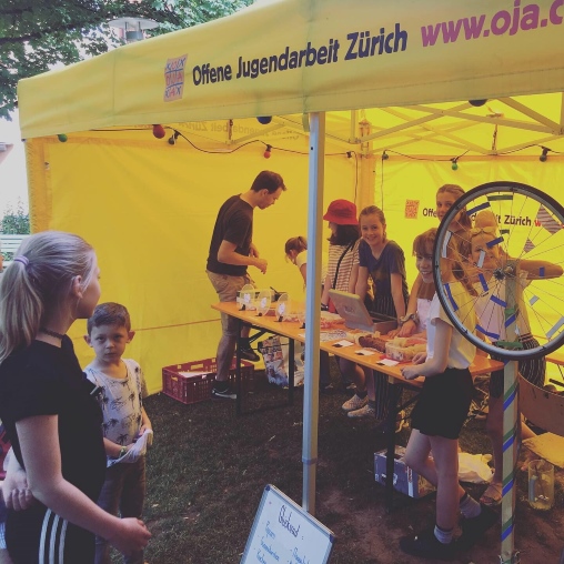 Stand der Offenen Jugendarbeit Zürich am Landenbergfest mit Zelt und Tisch