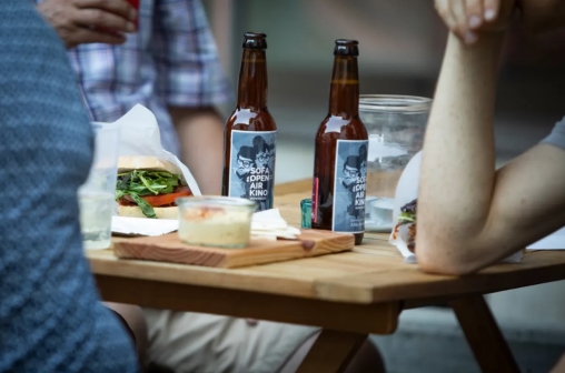 Es wird gegessen und Bier getrunken, das auf dem Tisch steht am Sofaopenairkino Wipkingen
