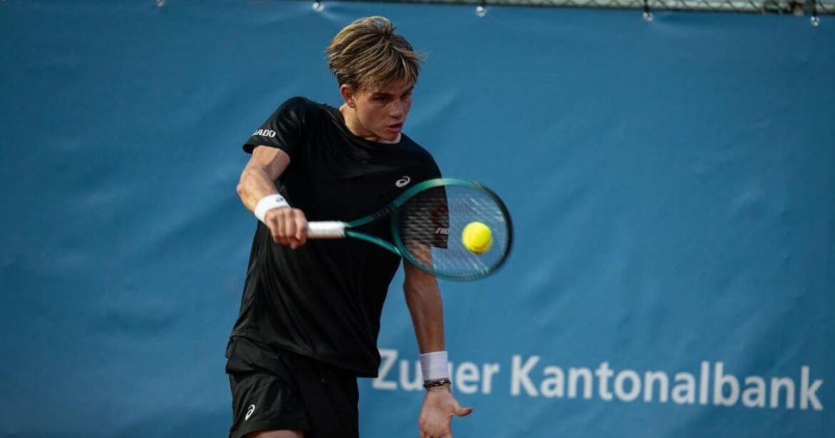 Henry Bernet trägt ein schwarzes T-Shirt und spielt Tennis am Zug Open, vor dem blauen Werbebanner der Zuger Kantonalbank.