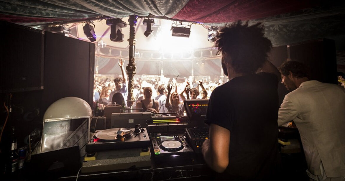 Ein DJ steht am DJ-Pult und schaut in die Menge, die zu seiner Musik abgeht. Rundfunk.fm beim Landesmuseum Zürich
