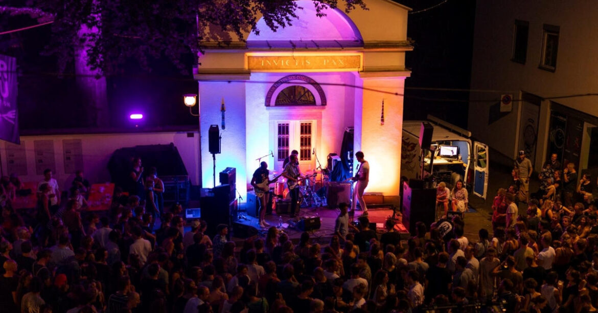Blick auf das Minifestival Invictis Pax in Luzern mit Band auf der Bühne und Publikum