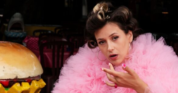 Lisa Christ sitzt neben einem künstlichen Burger für ihr neues Programm IDEAL