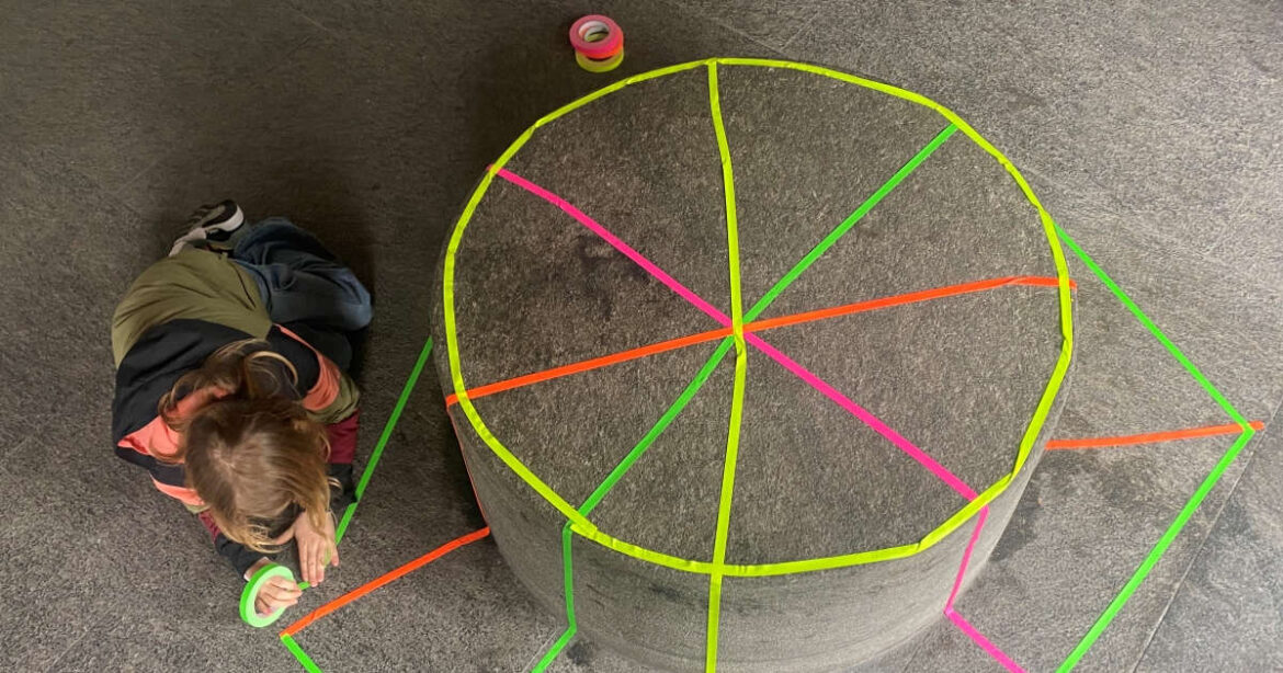 Ein Kind bastelt mit buntem Klebeband im K'werk Zug