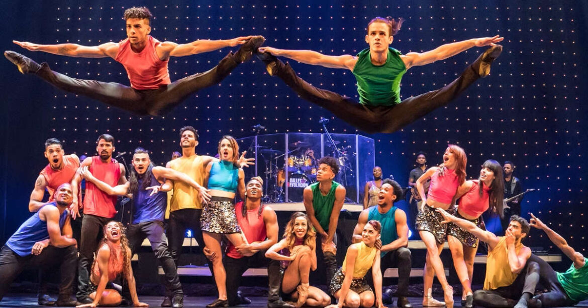 Ballett-Tänzer springen in die Luft mit der Crew zuschauend im Hintergrund auf der Bühne von Ballet Revolucion